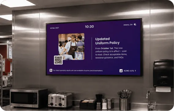 Interact digital signage in a staff break room announcing an updated uniform policy from October 1st with a QR code, showing 10:30 AM in Atlanta, GA.