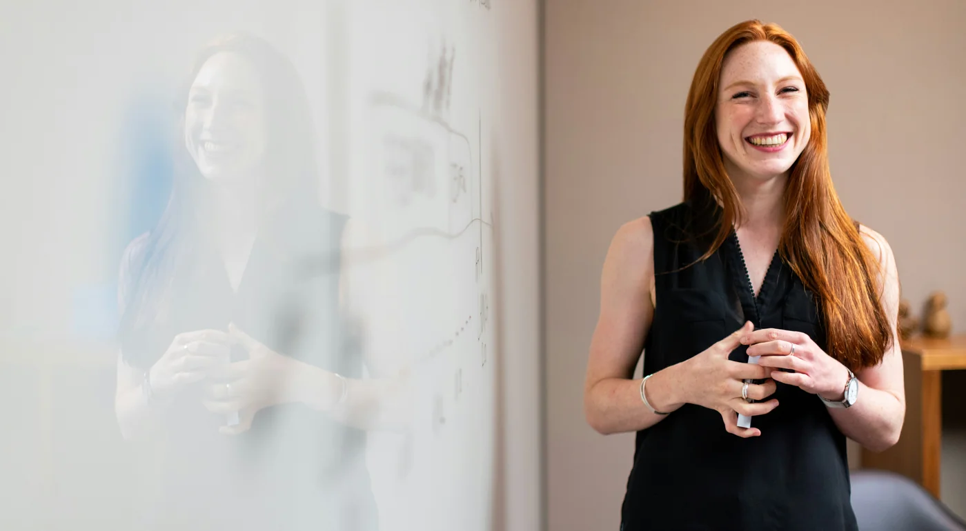 Smiling HR professional standing by a whiteboard in the office