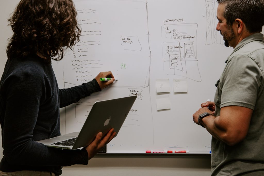 man and woman writing on whiteboard