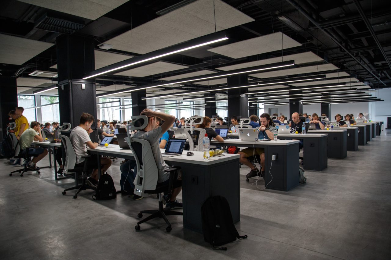 Large open office with casually dressed employees working at computer desks