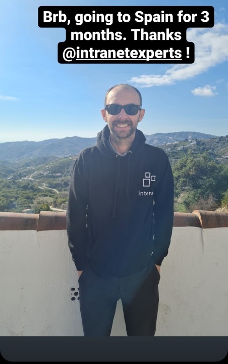 man wearing sunglasses stood on a balcony