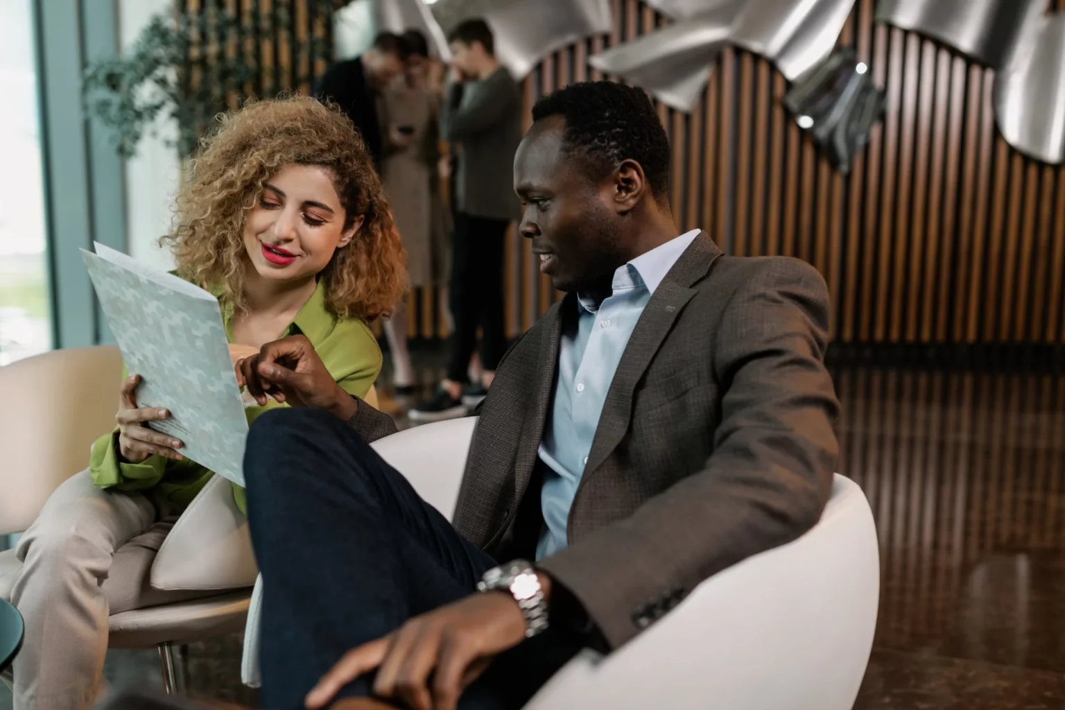 Co-workers reviewing document in comfy chairs