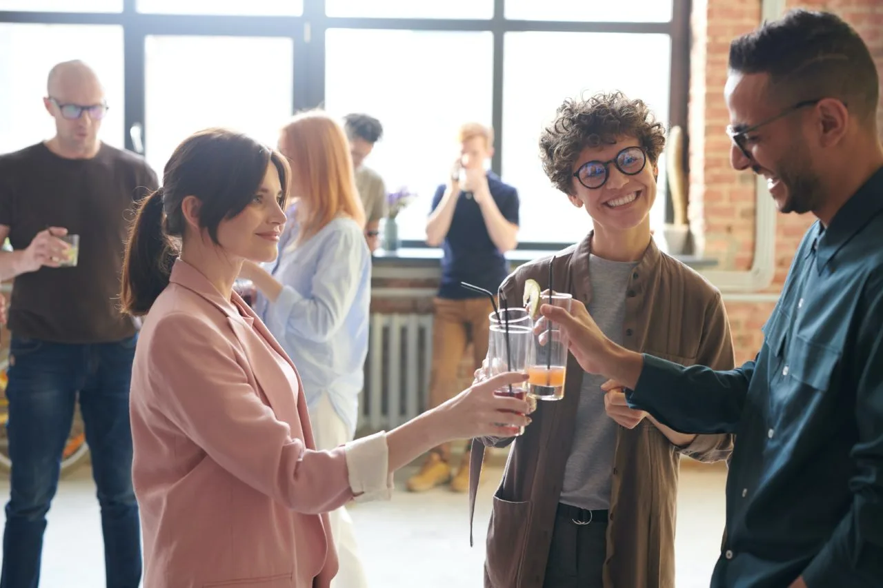 three people toasting cheers at a work event