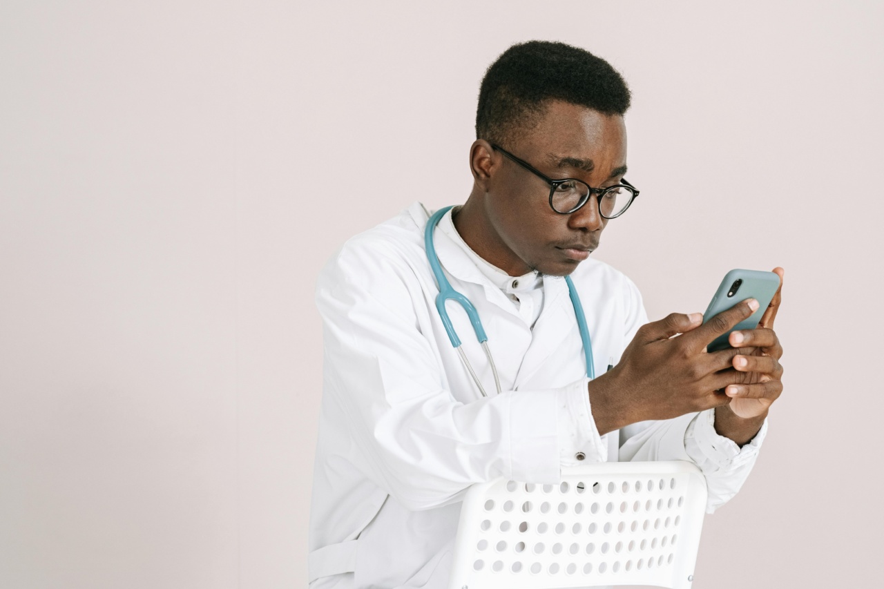 A young male healthcare worker engaging in deskless workforce communication on his smartphone