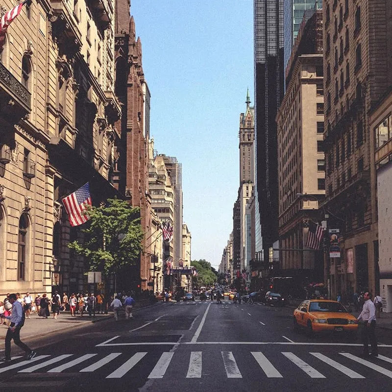 Enterprise intranet support from Interact's New York office, represented by a wide shot looking up a busy Manhattan avenue lined with American flags and yellow cabs.